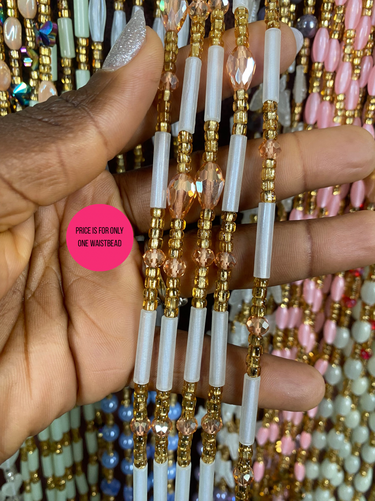 Hand holding a Beaded Subtle Glow in the dark waist beads with colorful beads in the background