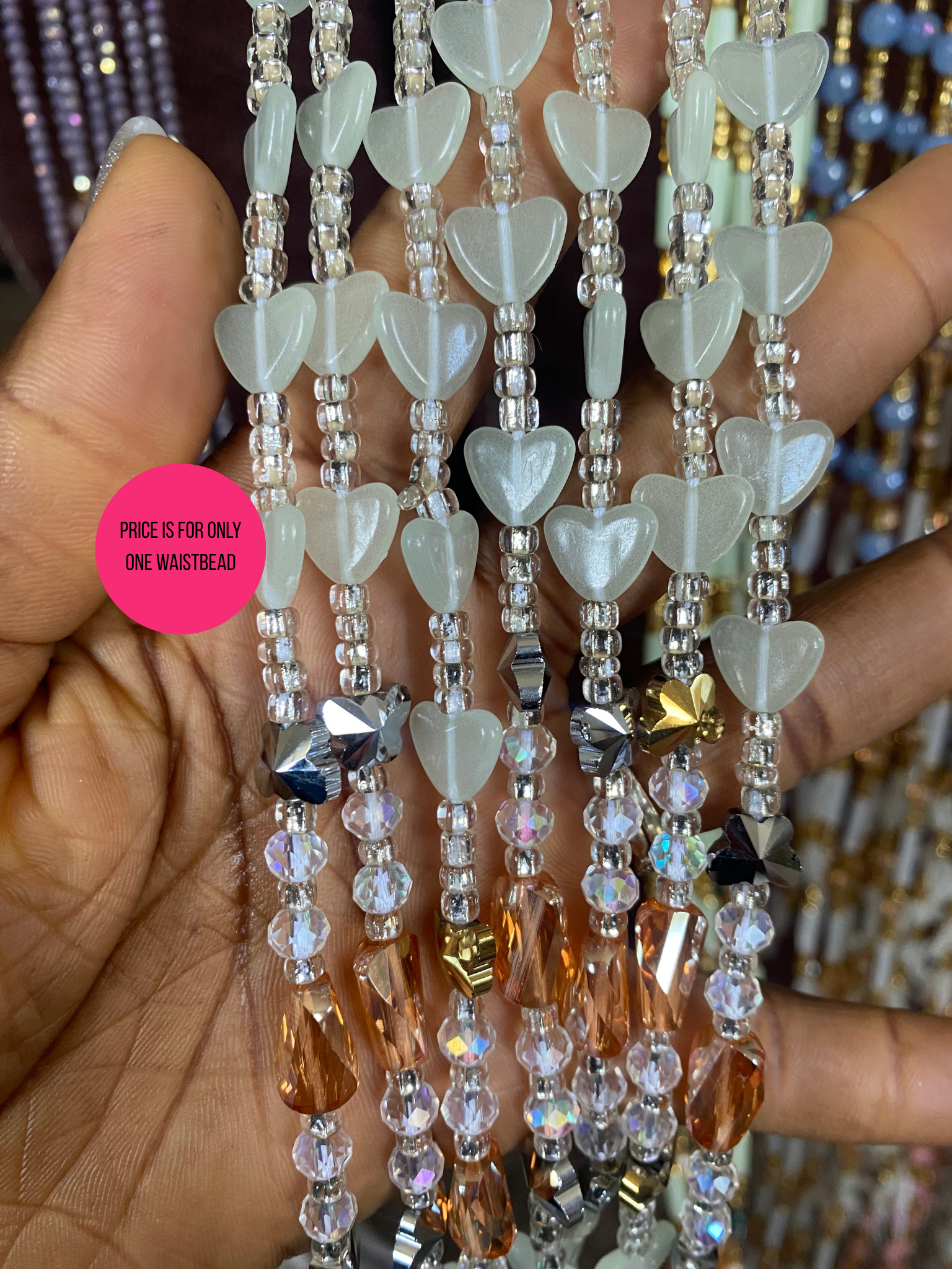Beaded Subtle Glow in the dark waist beads with heart-shaped beads held by a hand