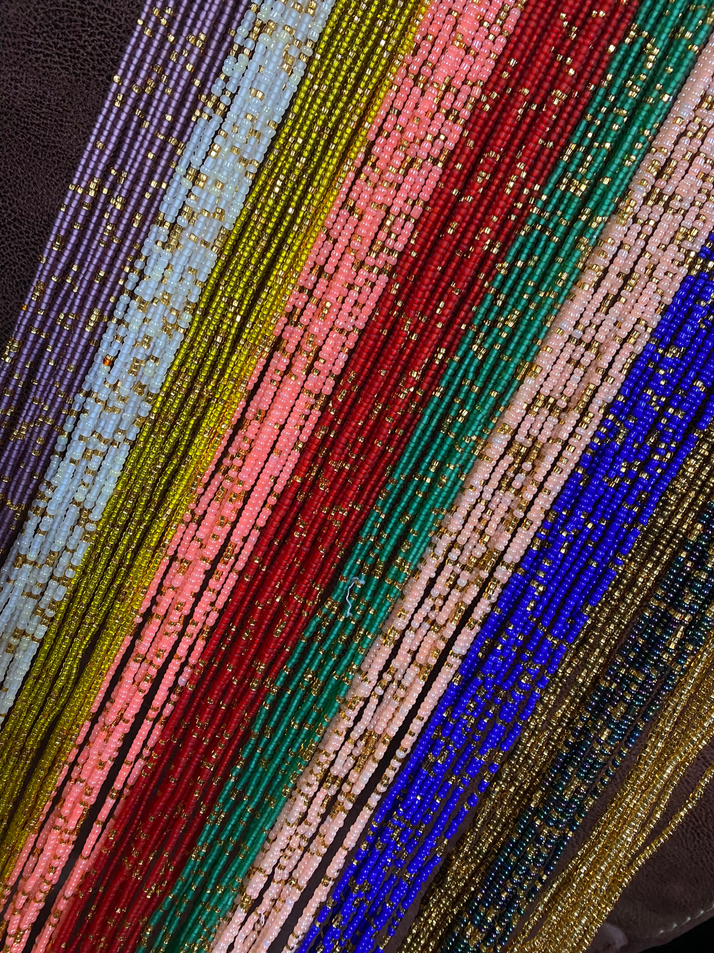 Close-up of colorful beaded Waist bead strands in various colors.