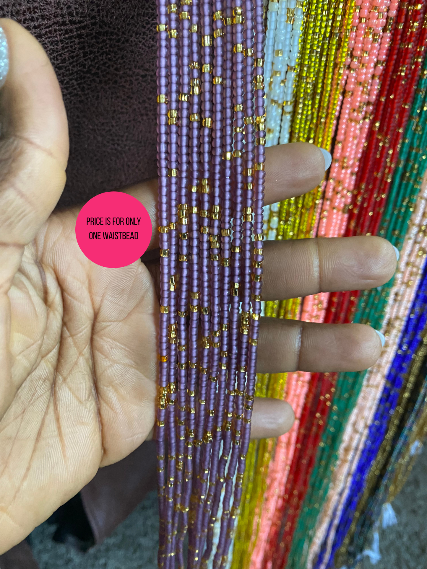 Colorful beaded waist bead held by a hand with a pink label indicating price.